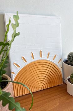 three potted plants sit on a wooden table next to a white and yellow wall