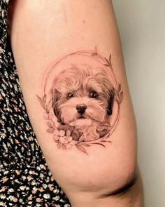 a small dog is shown in the center of this tattoo design on the right thigh