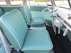 the interior of an old bus with blue leather seats and white wire baskets on it