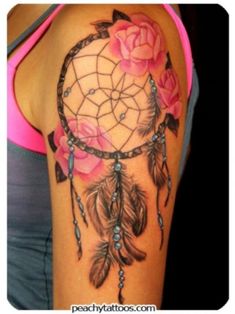 a woman's arm with a pink rose and dream catcher tattoo on it