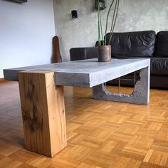 a table made out of concrete with a potted plant in the middle on top