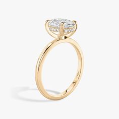 a yellow gold engagement ring with a pear shaped diamond on the top and side stones