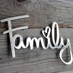 a metal family sign hanging on the side of a wooden wall