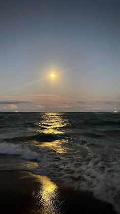 the sun is setting over the ocean with waves