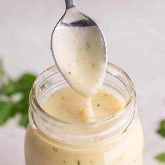 a spoon full of mayonnaise being lifted from a jar