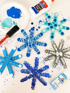 paper snowflakes and crafting supplies on a white background with the words abcdeleaning