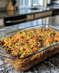 a glass casserole dish filled with noodles and ground beef on a kitchen counter