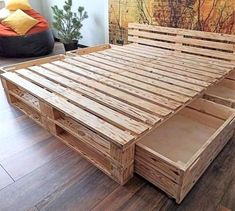 a bed frame made out of wooden pallets with drawers on the bottom and sides