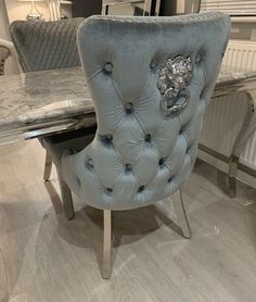 a blue chair sitting in front of a table with a mirror on top of it