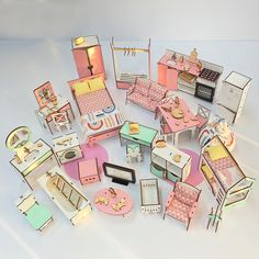 dollhouse furniture and accessories are arranged on a white surface