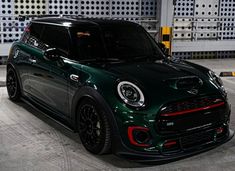 a green and black mini cooper parked in a garage