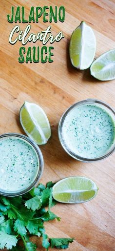 two glasses filled with cilantro sauce on top of a wooden table