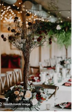 an elegant centerpiece with flowers and greenery is displayed on a long dining table