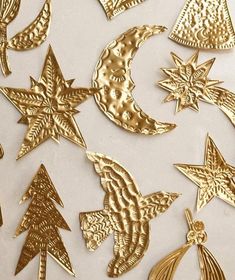 gold christmas ornaments are arranged on a white surface