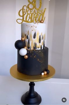 a black and white cake with gold decorations