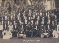 an old black and white photo of men in formal wear posing for a group photograph