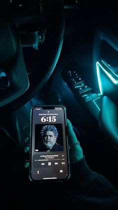 a cell phone sitting on the dashboard of a car with an image of george bush