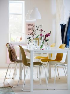 a white table topped with lots of colorful chairs