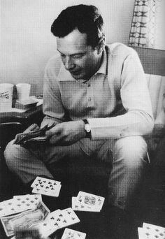 a man sitting on top of a chair surrounded by playing cards