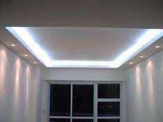 an empty room with white walls and lights on the ceiling is lit by recessed lighting