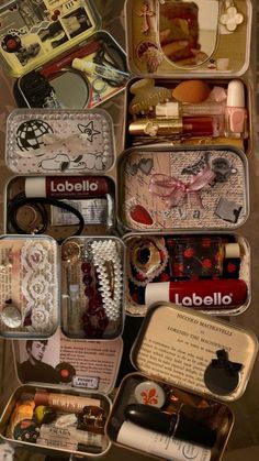 an open suitcase filled with lots of assorted items on top of a table in front of a wall