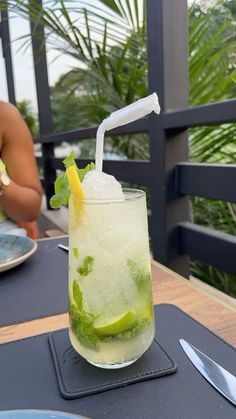 there is a drink with lime and ice on the table