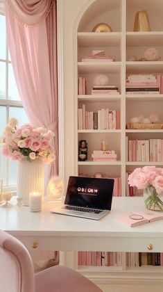 a laptop computer sitting on top of a white desk in front of a book shelf