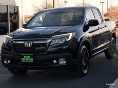 the front end of a black honda ridge sport utility vehicle parked in a parking lot