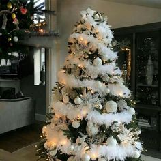 a white christmas tree decorated with ornaments and lights