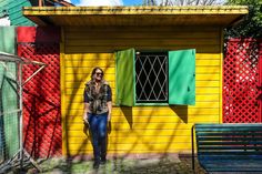 a woman standing in front of a colorful building