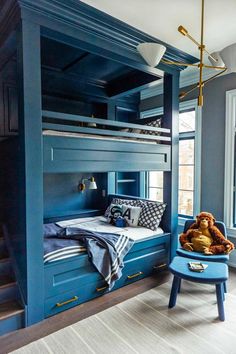 a blue bunk bed sitting next to a window