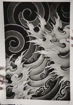 a person holding up a black and white photo with an artistic wave design on it