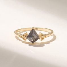 a gold ring with a gray diamond on it