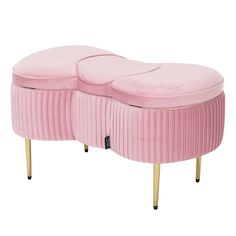 a pink bench with gold legs and an oval shaped cushion on the top, sitting in front of a white background