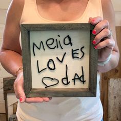 a woman holding up a framed sign with the words media loves dad written on it