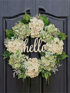 a wreath with the word hello written on it and some flowers in front of it