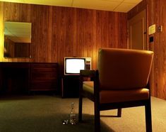 a chair and television in a room with wood paneling