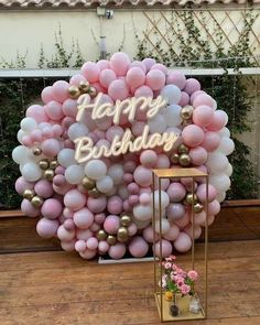 a balloon arch with the words happy birthday written on it and balloons in front of it