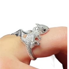 a silver ring with a lizard on it's finger