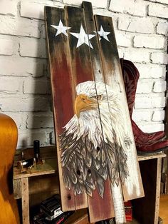 an eagle painted on top of a wooden sign next to a guitar case and other items