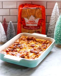 a casserole dish sitting on top of a counter next to some christmas trees