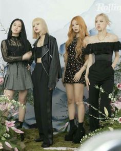 four girls standing in front of a backdrop with flowers and plants on it's sides