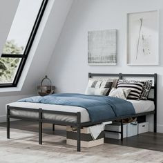 a bed sitting under a window in a bedroom next to a wooden floor and white walls