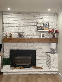 a living room with a white brick fireplace and wooden mantles on either side of the fire place