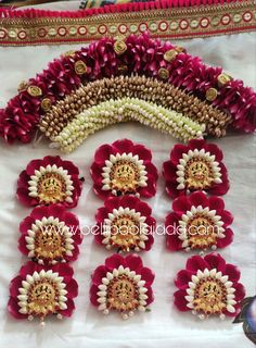 red and white flowers arranged in rows on a table with other items around it for decoration