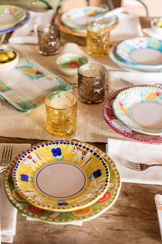 the table is set with colorful plates and glasses