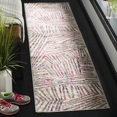 a pair of shoes sitting on top of a rug next to a window