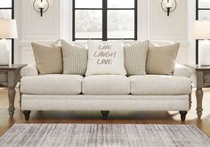 a living room filled with furniture and pillows on top of a hard wood floored floor