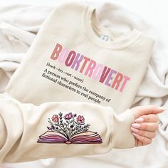 a person holding an open book with flowers on it and the words b outrivert printed on them