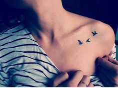 a woman with a small bird tattoo on her chest